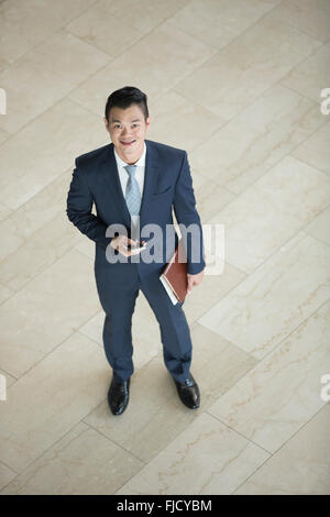 Erhöhte Ansicht eines glücklichen asiatischen Geschäftsmann in die Kamera schaut. Stockfoto