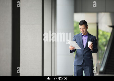 Chinesischer Mann mit einem Tabletcomputer. Asiatische Geschäftsmann mit digitalen Tablettcomputer. Stockfoto