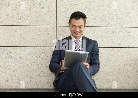 Chinesischer Mann mit einem Tabletcomputer. Asiatische Geschäftsmann mit digitalen Tablettcomputer. Stockfoto