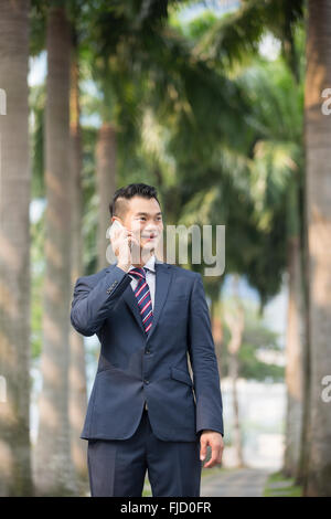 Ein glücklich chinesischen Geschäftsmann mit seinem Smartphone. Stockfoto