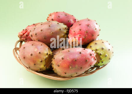 Feigenkaktus (Opuntia) Früchte in der Wicker-Platte-Nahaufnahme auf grünem Hintergrund Stockfoto