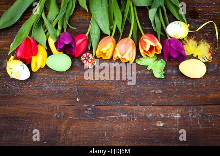 Ostereier und frische Frühlingsluft Tulpen auf verwittertem Holz Hintergrund Stockfoto