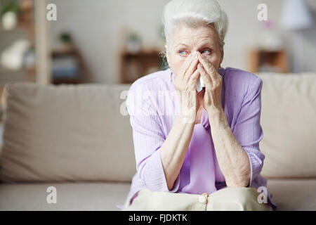 Traurige senior Frau auf Sofa sitzen und Weinen Stockfoto