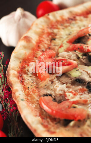 Gebackene Pizza mit Tomaten, Champignons und Hähnchenfleisch vertikale. Geringe Schärfentiefe Stockfoto