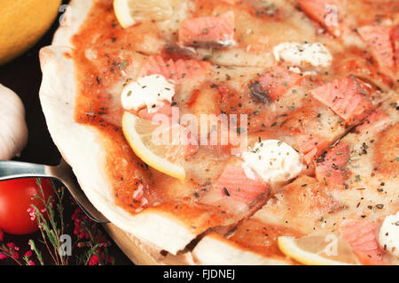 Leckere italienische Pizza mit Lachs, Zitrone und Käse. Geringe Schärfentiefe Stockfoto