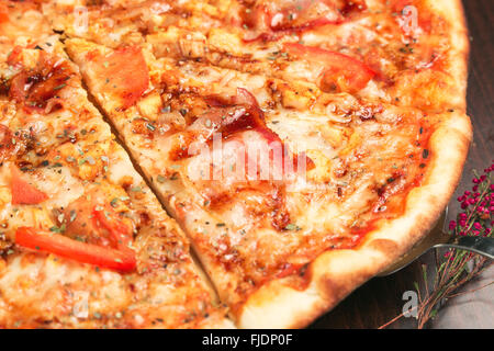 Lecker italienische Pizza mit Speck und Tomaten hautnah. Geringe Schärfentiefe Stockfoto