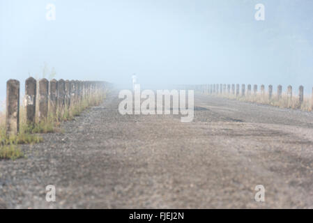 Einsamer Mann läuft an nebligen Herbstmorgen Stockfoto