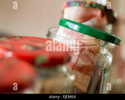 Gläser von Bargeld. Glasgläser mit Banknoten Stockfoto