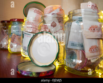 Gläser von Bargeld. Glasgläser mit Banknoten Stockfoto