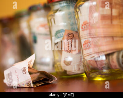 Gläser von Bargeld. Glasgläser mit Banknoten Stockfoto