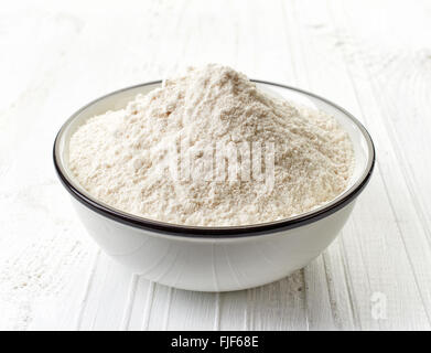 Schüssel mit weißem Mehl auf weißer Holztisch Stockfoto