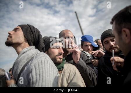 Idomeni, Griechenland. 2. März 2016. Flüchtlinge stehen in die Flüchtlingslager, um registrieren Sie sich und Zigaretten zu teilen, während sie an der griechisch-mazedonischen Grenze in Idomeni, Griechenland, 2. März 2016 warten. Seit Montag hat Mazedonien kaum keine Flüchtlinge geben lassen. An der Grenze in Idomeni wurde ein großes Lager mit Tausenden von Flüchtlingen gebaut. Foto: MICHAEL KAPPELER/Dpa/Alamy Live News Stockfoto