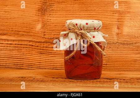 Ein Glas hausgemachte Quitten Marmelade mit Top Textildekoration unlackiert braun Vintage Wood Stockfoto