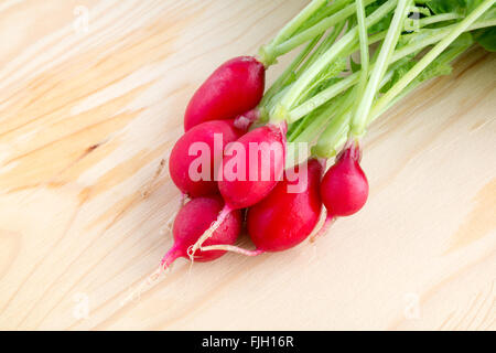 Frischen Haufen von Radieschen, Raphanus Sativus, auf Holzplatte bereit zu essen oder in gesunden Salaten hinzufügen Stockfoto