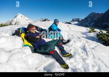 Bergsteiger sitzt auf einem Berg im Schnee Piste und nehmen ein Sonnenbad, Karwendel, Tirol, Österreich Stockfoto