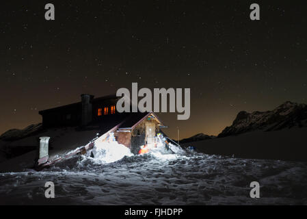 Menschen mit Scheinwerfer beleuchten die Winter Zuflucht der Falcon-Hütte in einer sternklaren Nacht im Karwendelgebirge, Tirol, Österreich Stockfoto