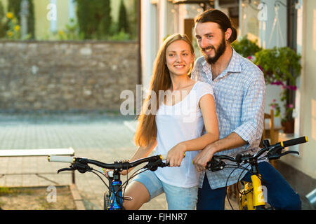 Nahaufnahme eines jungen Liebespaar mit Fahrrädern in der Nähe der Wand Stockfoto