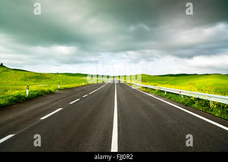 Toskana, geraden Straße ländlichen Landschaft der Toskana mit gelben und grünen Bereich. Sanfte Hügellandschaft in der Nähe von Volterra, Italien. Europa. Stockfoto