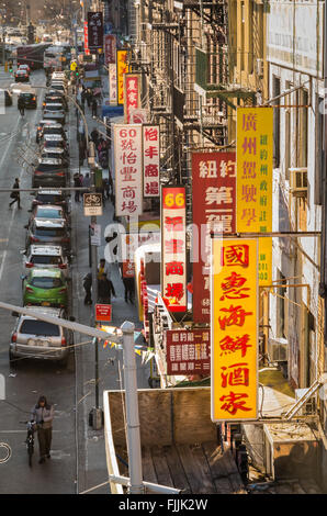 Blick von oben auf eine typische Straße in Chinatown in New York City, mit Ladenschilder auf Chinesisch auf den Seiten von Gebäuden Stockfoto