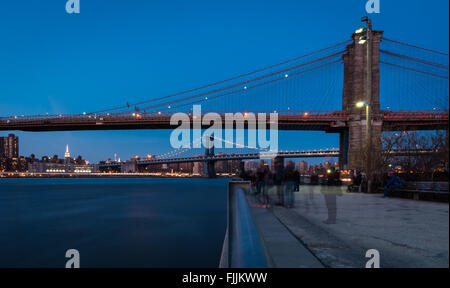 Blick auf die Brooklyn Bridge und Manhattan Bridge in der Dämmerung an der Promenade im Brooklyn Bridge Park / Dumbo. Stockfoto