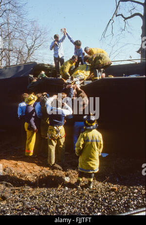 Hyattstown, Maryland, USA, 1978 Montgomery County, Maryland Ersthelfer verletzte Ingenieur aus einem entgleisten Zug, der Feuer gefangen zu entfernen und tragen ihn zu einem wartenden Maryland State Police Helikopter Flug nach Trauma Center Krankenhaus. Bildnachweis: Mark Reinstein Stockfoto