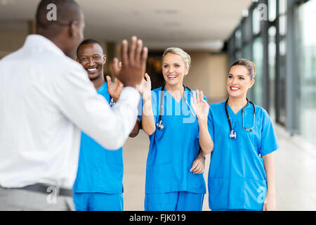 Heckansicht des Patienten wehenden Abschied von freundlichen Ärzteteam Stockfoto