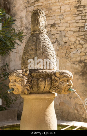 Die Fontaine des Mascarons, einer alten Steinbrunnen im historischen Dorf von Seguret, Vaucluse, Provence, Frankreich Stockfoto