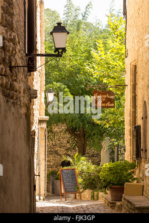 Ein Restaurant auf einem typischen schmalen gepflasterten Straße in der alten historischen Dorf Seguret, Vaucluse, Provence, Frankreich Stockfoto