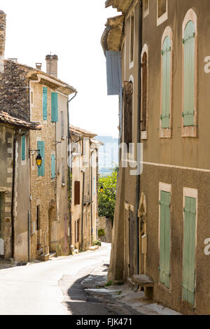 Alten Steinhäusern mit bemalten Fensterläden auf einer schmalen Straße im Dorf Vinsobres, Côtes du Rhône, Provence, Frankreich Stockfoto