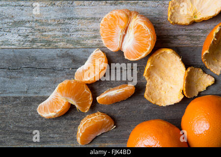 Mandarine Abschnitte und Schalen auf alten Holztisch. Stockfoto