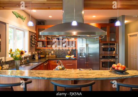Frühstücksbar in zeitgenössischen gehobenen Küche mit Granit-Arbeitsplatten, Edelstahlgeräte und Akzentbeleuchtung Stockfoto