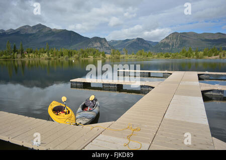 Kajaks am Berg Dock auf Dillon Reservoir in Colorado. Ein paar schwebende Kajaks an einem Dock auf einer reflektierenden Bergsee. Stockfoto