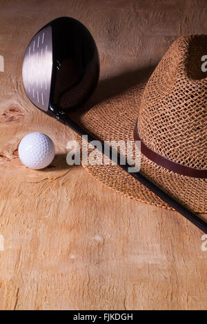 Siesta - Stroh Hut und Golf-Fahrer auf einem Holztisch Stockfoto