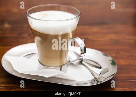 Cappuccino. Tasse Kaffee mit Milchschaum steht auf Holztisch in cafeteria Stockfoto