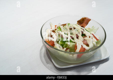 Schüssel mit Caesar Salat mit Speck auf weißen Tisch Stockfoto