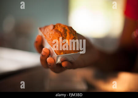 Ein weiblicher Bäcker hält eines ihre hausgemachten Kuchen, Tansania Stockfoto