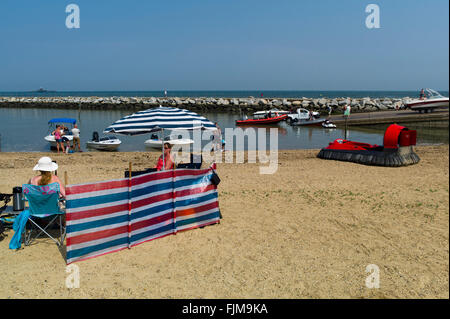 Leute sitzen am Strand von Herne Bay Stockfoto