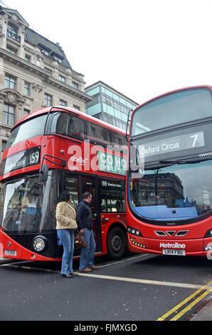 London, UK, 3. März 2016, Fußgänger Quetschen zwischen 2 Busse bei der Kreuzung von Oxford Street, das West End. Stockfoto