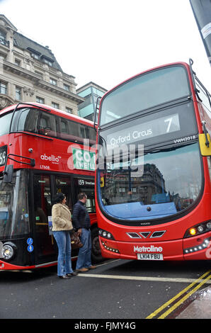 London, UK, 3. März 2016, Fußgänger Quetschen zwischen 2 Busse bei der Kreuzung von Oxford Street, das West End. Stockfoto