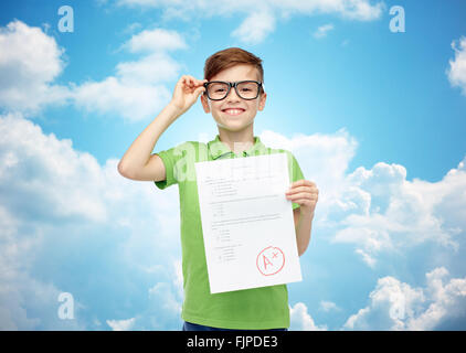 fröhlicher Junge in Brillen halten Schule Testergebnis Stockfoto