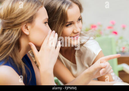 lächelnde junge Frauen bei Freiluft-Café Klatsch Stockfoto