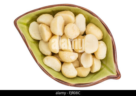 Macadamia-Nüssen in einer isolierten Blatt geformt Keramikschale, Ansicht von oben Stockfoto