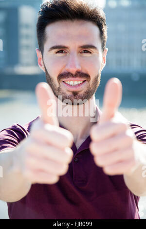 Attraktive junge Mann Daumen auftauchen Stockfoto