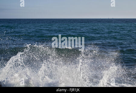 Leistungsstarke erscheint Wellen brechen auf felsigen Strand und Wasser-Schaum-spray Stockfoto