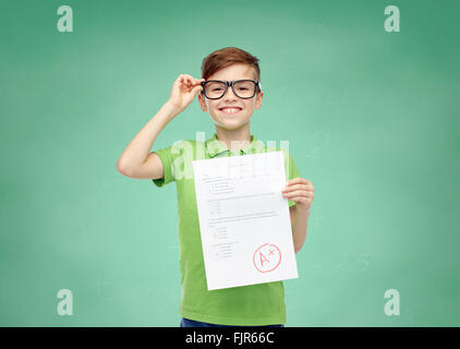 fröhlicher Junge in Brillen halten Schule Testergebnis Stockfoto