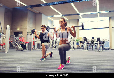junger Mann und Frau mit Langhantel im Fitness-Studio trainieren Stockfoto