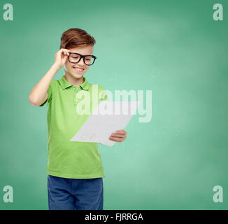 fröhlicher Junge in Brillen halten Schule Testergebnis Stockfoto