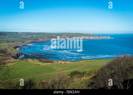 Blick über Robin Hoods Bay von der Landzunge bei Ravenscar North Yorkshhire UK mit einem Hotel-Golfplatz im Vordergrund Stockfoto