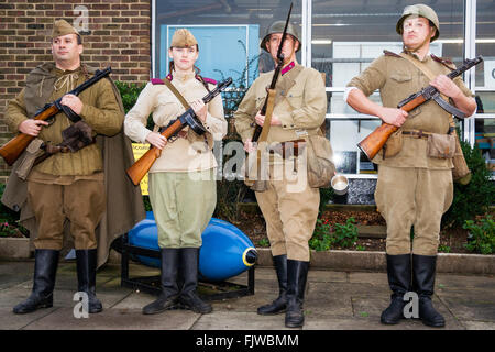 Weltkrieg zwei Re-enactment. Vier russische Soldaten steht dabei mit dem Gesicht Viewer, posierend, drei Männer, eine Frau mit Gewehren und burp-gun, PPSh-41. Stockfoto