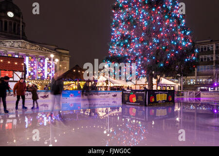 Leute Skaten rund um den Weihnachtsbaum auf der Eisbahn in der Alten Marktplatz, Nottingham, England, Großbritannien Stockfoto